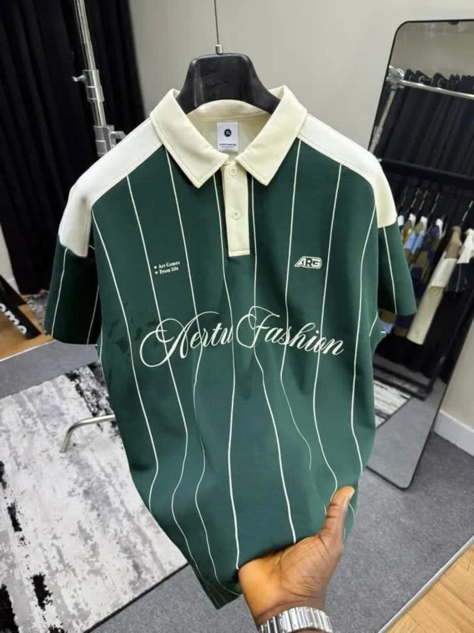 Green and white striped polo shirt with 'Hertz Fashion' branding on a hanger.