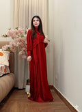 Woman in a red dress standing in a room with floral decorations.