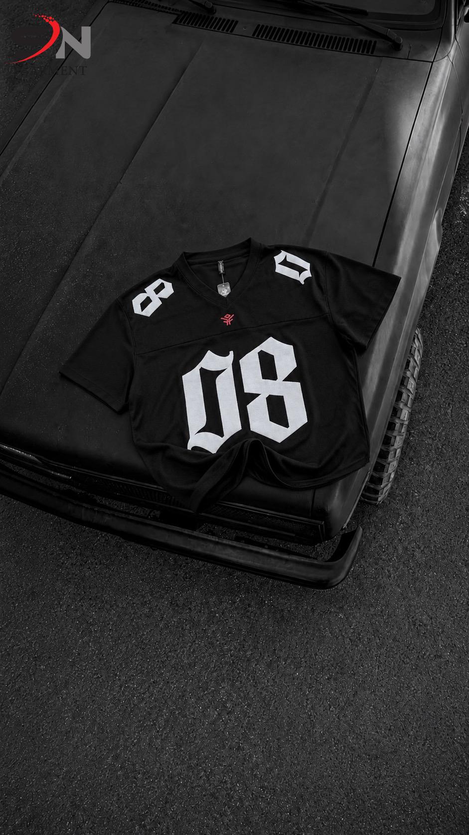 A black short-sleeve football-style jersey with large white '08' numerals on the front and white shoulder numbers, laid flat on the hood of a dark vehicle.